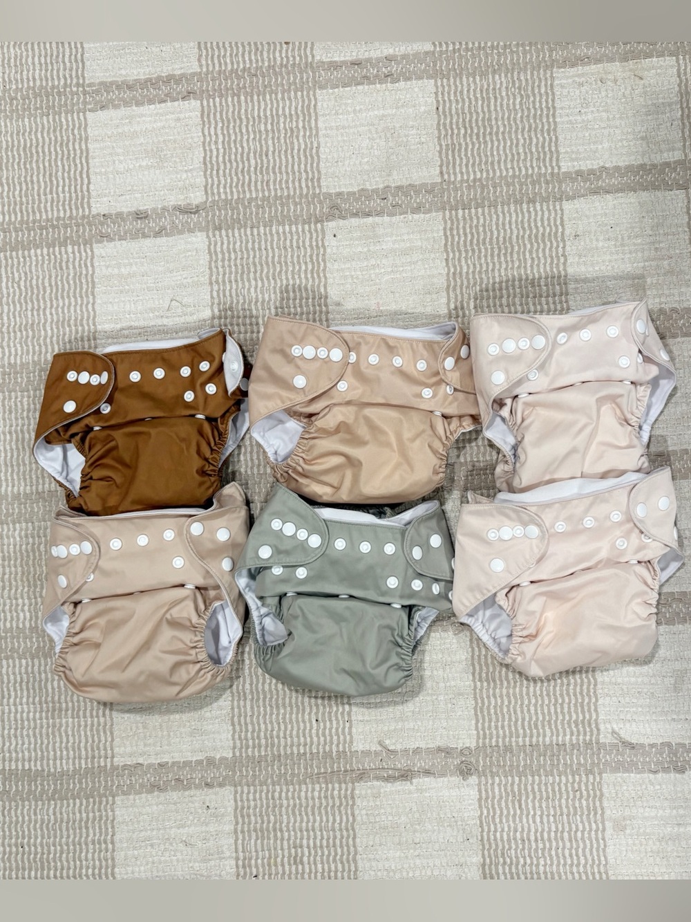 Nora’s nursery diapers in neutral pink colors